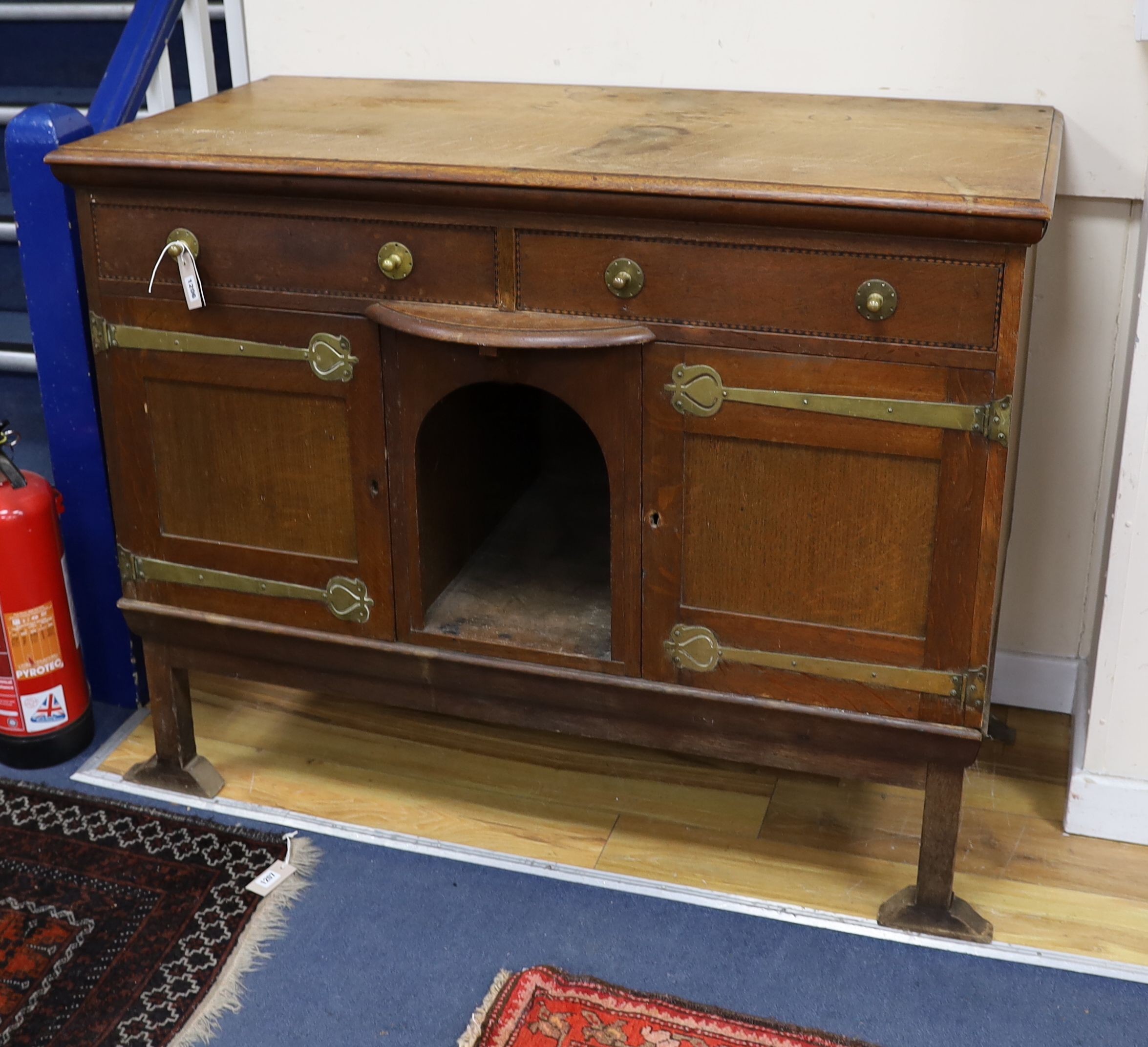 An Art Nouveau brass mounted oak buffet in the style of Voysey, length 124cm, depth 60cm, height 99cm